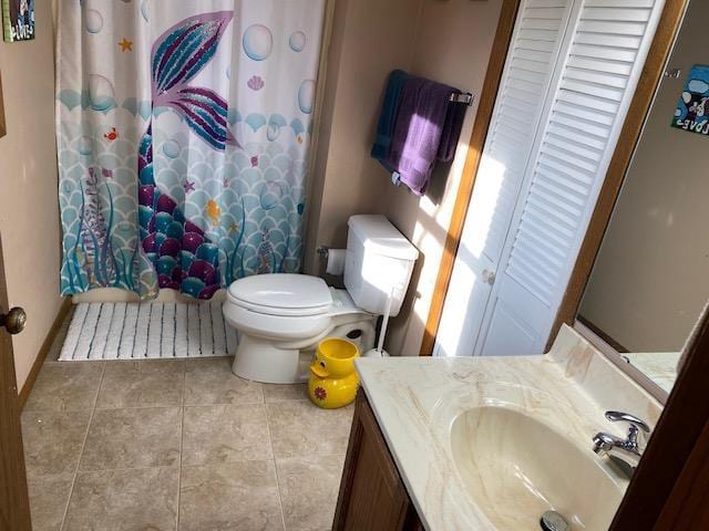 bathroom with walk in shower, vanity, toilet, and tile patterned floors