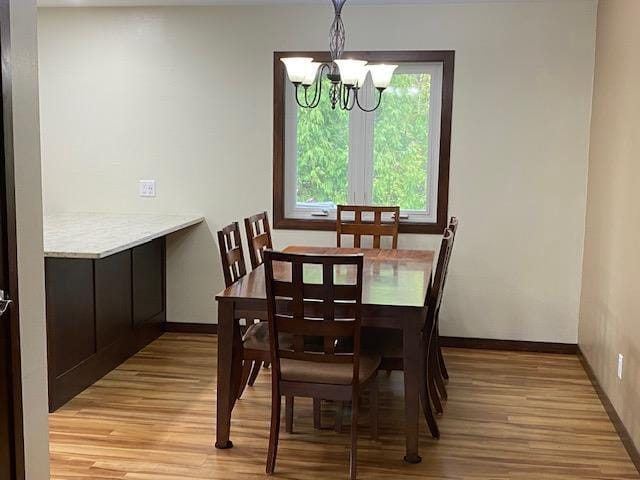 dining space with an inviting chandelier and light hardwood / wood-style flooring