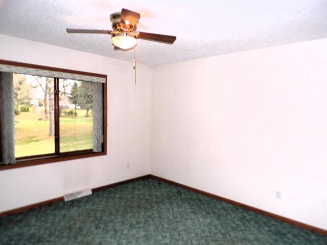 701 S Adams St, Thorp, WI 54771 - unfurnished room with dark colored carpet, ceiling fan, a textured ceiling, and baseboards