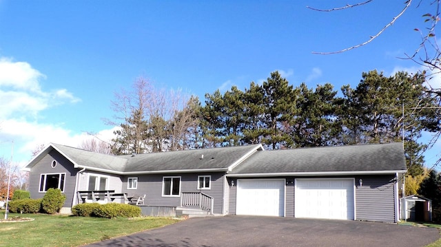 single story home with a front lawn, a shed, and a garage