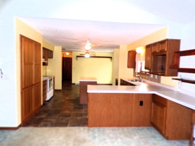 701 S Adams St, Thorp, WI 54771 - kitchen featuring a ceiling fan, brown cabinets, a sink, a peninsula, and range