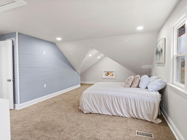 carpeted bedroom featuring multiple windows and vaulted ceiling