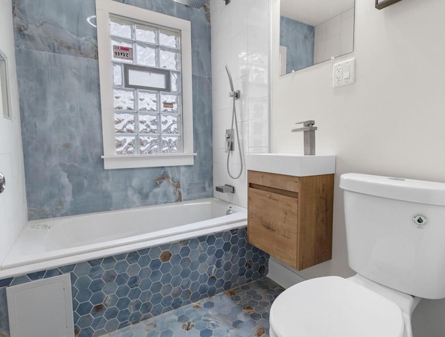 full bathroom featuring tile patterned floors, vanity, tiled shower / bath, and toilet