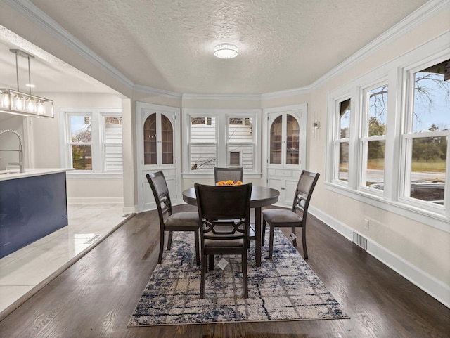 dining area featuring dark hardwood / wood-style floors, a healthy amount of sunlight, and a textured ceiling