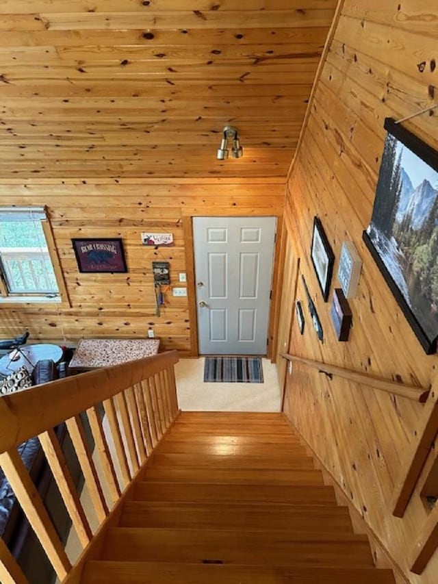 stairs with hardwood / wood-style floors, wood walls, and wood ceiling