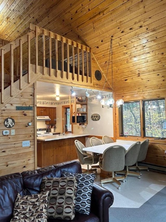 dining space featuring high vaulted ceiling, wooden walls, and wood ceiling