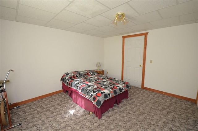 carpeted bedroom featuring a drop ceiling