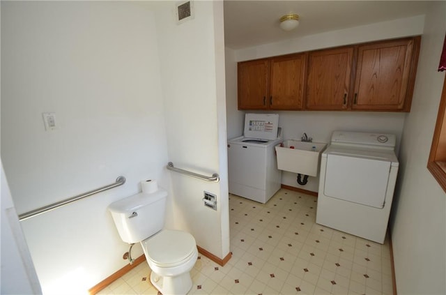 bathroom featuring washing machine and dryer and sink