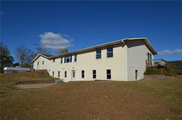 back of house featuring a lawn and central AC