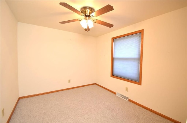 carpeted spare room featuring ceiling fan