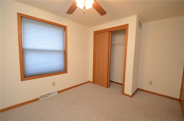 unfurnished bedroom featuring light carpet, a closet, and ceiling fan