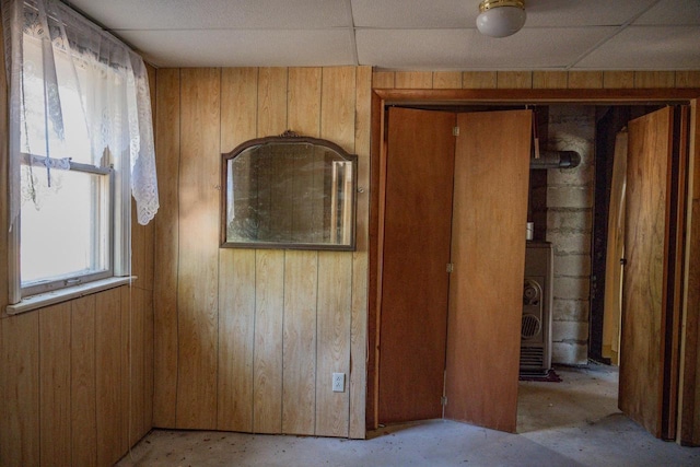 empty room with a paneled ceiling and wooden walls