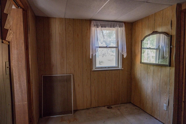 unfurnished room featuring wood walls