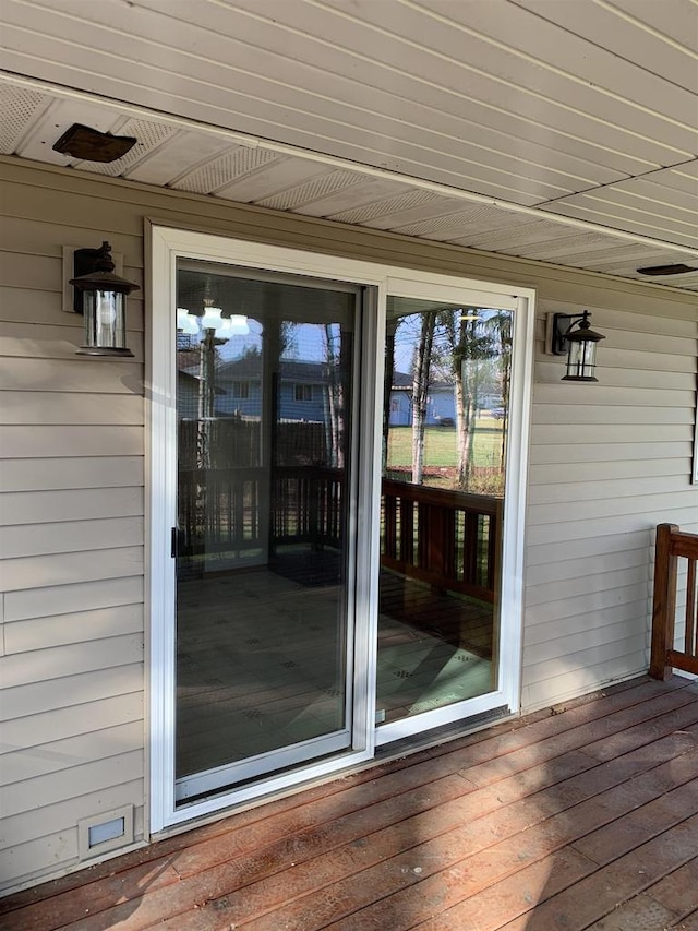 view of exterior entry with a wooden deck