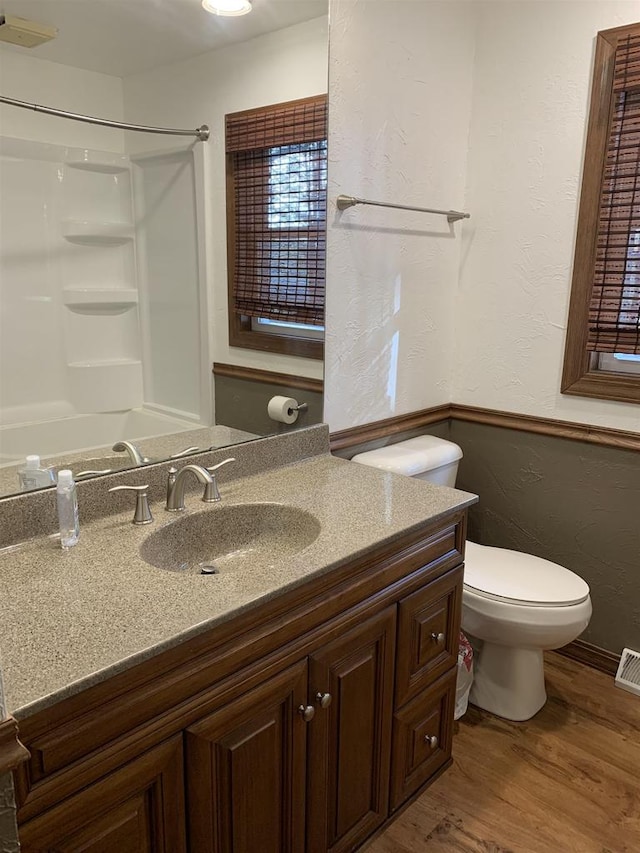 bathroom featuring walk in shower, vanity, toilet, and hardwood / wood-style flooring