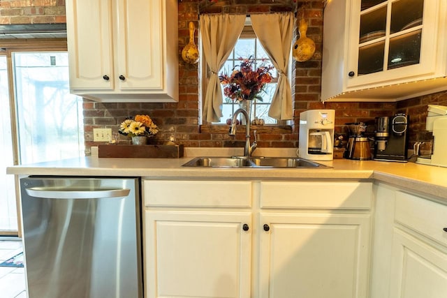 kitchen featuring stainless steel dishwasher, white cabinetry, and sink