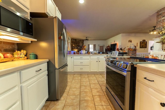 kitchen featuring white cabinets, stainless steel appliances, and light tile patterned floors