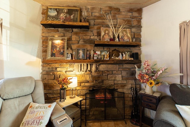 interior space with a stone fireplace, hardwood / wood-style floors, and a textured ceiling