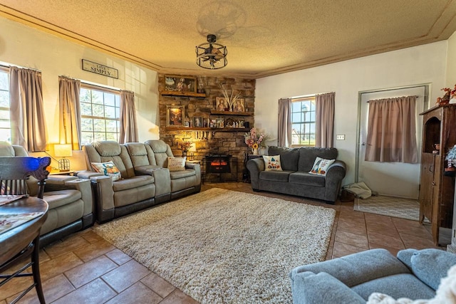 living room featuring a stone fireplace, a textured ceiling, and crown molding