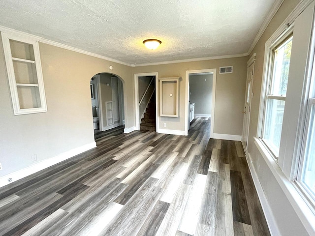 unfurnished room featuring a textured ceiling, dark hardwood / wood-style flooring, and crown molding