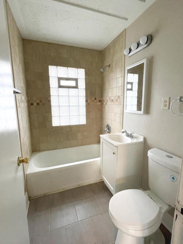 full bathroom featuring tiled shower / bath, a textured ceiling, vanity, tile patterned floors, and toilet