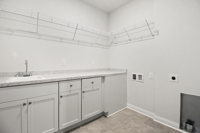 clothes washing area with hookup for an electric dryer, hookup for a washing machine, cabinets, and sink