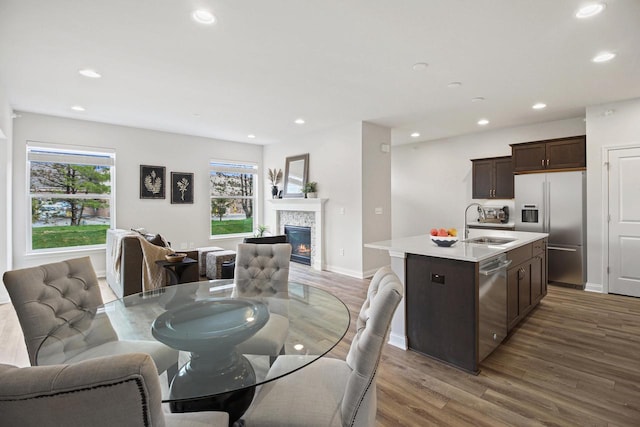 dining space with a fireplace, hardwood / wood-style floors, and sink