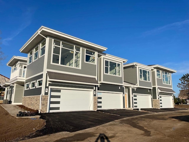 1432 Tenny Ave Unit 201, Waukesha, WI 53189 - view of property exterior with an attached garage, stone siding, and driveway
