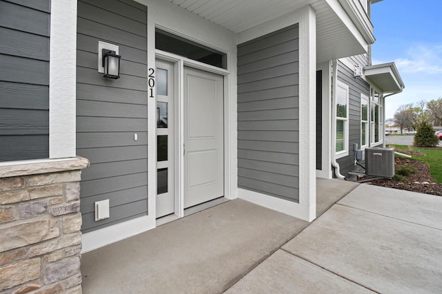 entrance to property with cooling unit and covered porch