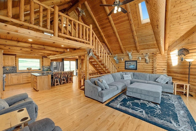E7498 Mill Rd, Spring Green, WI 53588 - living area featuring log walls, a wood ceiling with exposed beams, high vaulted ceiling, ceiling fan, and light wood-type flooring