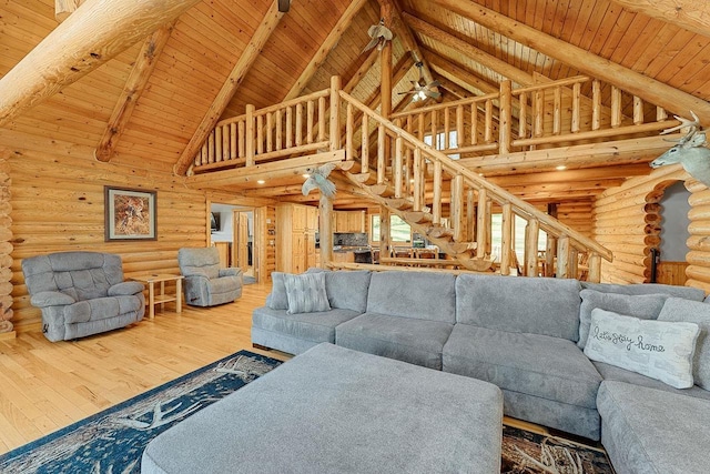 E7498 Mill Rd, Spring Green, WI 53588 - living room featuring log walls, high vaulted ceiling, wood finished floors, a wooden ceiling with exposed beams, and stairs
