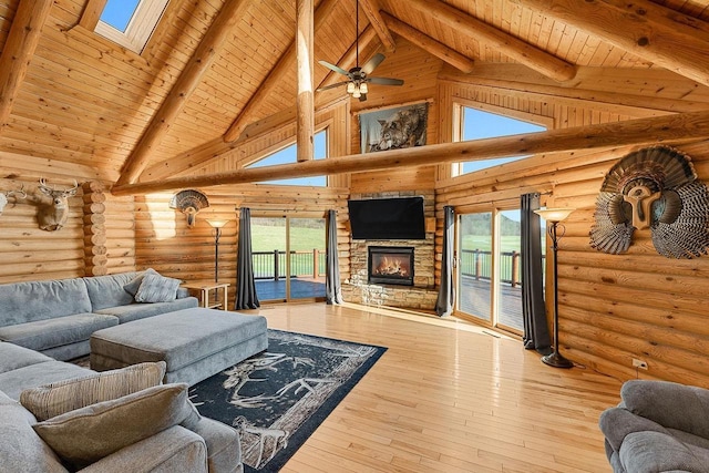 E7498 Mill Rd, Spring Green, WI 53588 - living area with a wood ceiling with exposed beams, high vaulted ceiling, a skylight, a stone fireplace, and hardwood / wood-style floors