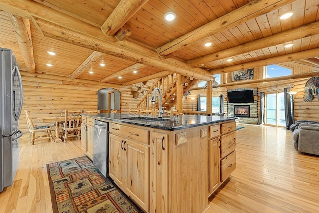 E7498 Mill Rd, Spring Green, WI 53588 - kitchen with rustic walls, stainless steel appliances, a wooden ceiling with exposed beams, a stone fireplace, and open floor plan