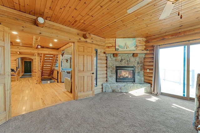 E7498 Mill Rd, Spring Green, WI 53588 - unfurnished living room with rustic walls, a stone fireplace, carpet, wooden ceiling, and a ceiling fan