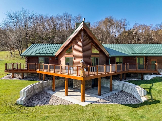 E7498 Mill Rd, Spring Green, WI 53588 - rear view of house featuring log siding, a chimney, a deck, and a lawn
