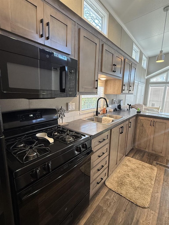 kitchen featuring hanging light fixtures, black appliances, sink, and dark hardwood / wood-style floors