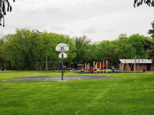 view of sport court with a playground and a lawn