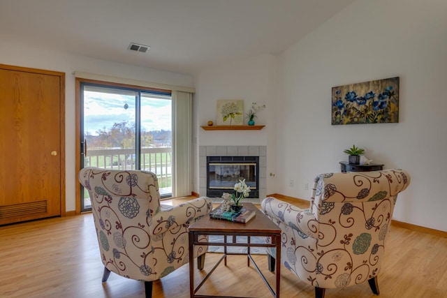 living room featuring light hardwood / wood-style floors and a tile fireplace