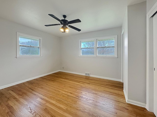 unfurnished bedroom with light wood-type flooring, multiple windows, and ceiling fan