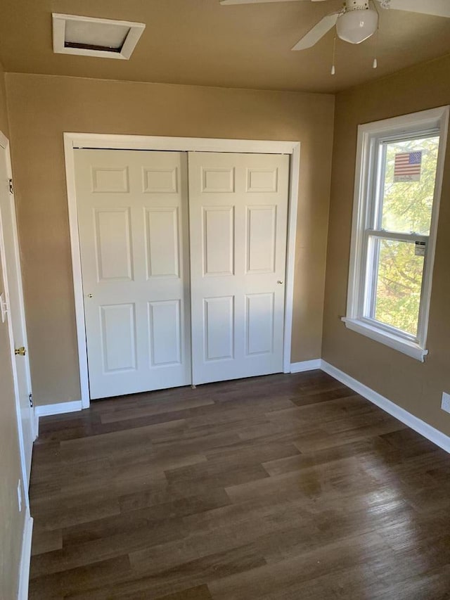 unfurnished bedroom with ceiling fan, dark hardwood / wood-style floors, and a closet