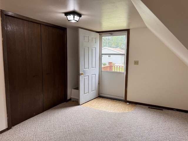 bonus room with light colored carpet, a textured ceiling, and vaulted ceiling