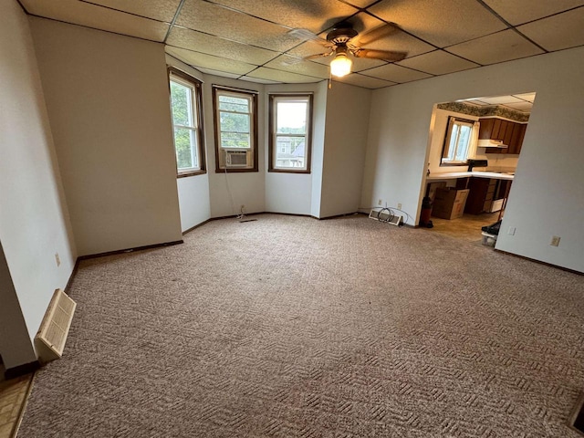 empty room featuring carpet, a paneled ceiling, ceiling fan, and cooling unit