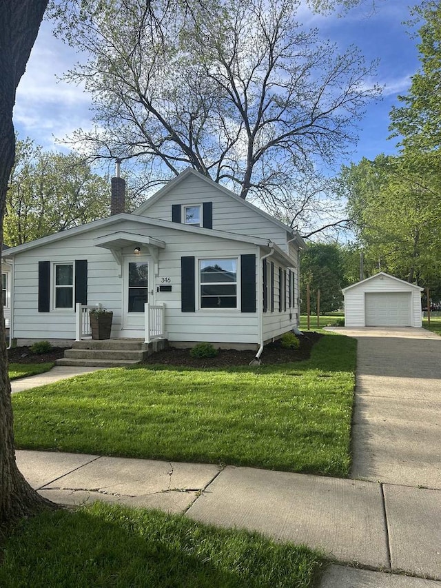 bungalow-style house with an outbuilding, a garage, and a front lawn