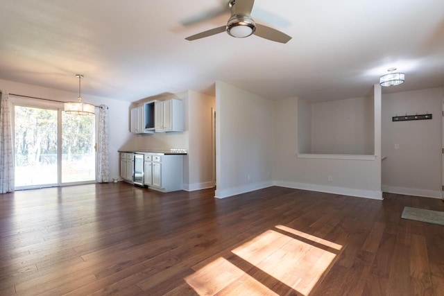 unfurnished living room with dark wood-type flooring, beverage cooler, and ceiling fan