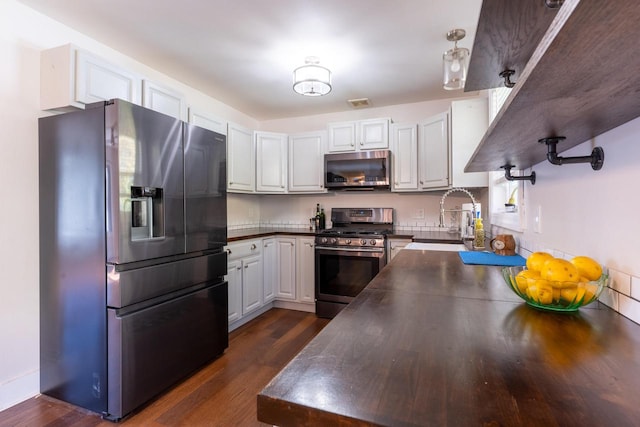 kitchen with white cabinetry, appliances with stainless steel finishes, sink, and dark hardwood / wood-style floors