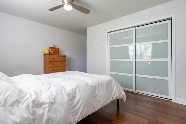 bedroom with ceiling fan, dark hardwood / wood-style floors, and a closet