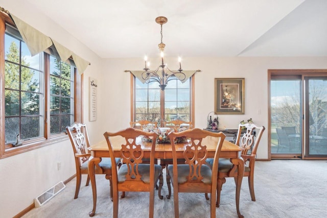 dining area with light colored carpet and a chandelier