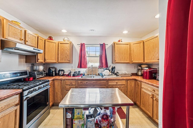 kitchen with stainless steel gas stove, sink, and light tile patterned floors