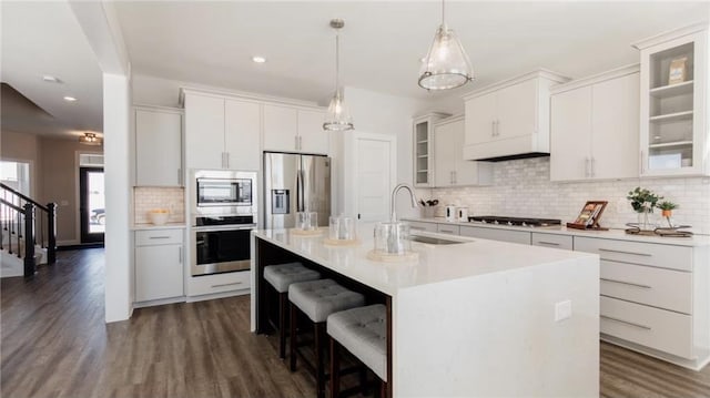 kitchen featuring light countertops, appliances with stainless steel finishes, glass insert cabinets, white cabinetry, and a sink