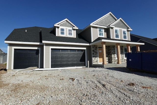 1581 Creekview Ln, Oconomowoc, WI 53066 - craftsman-style house with covered porch, an attached garage, and gravel driveway